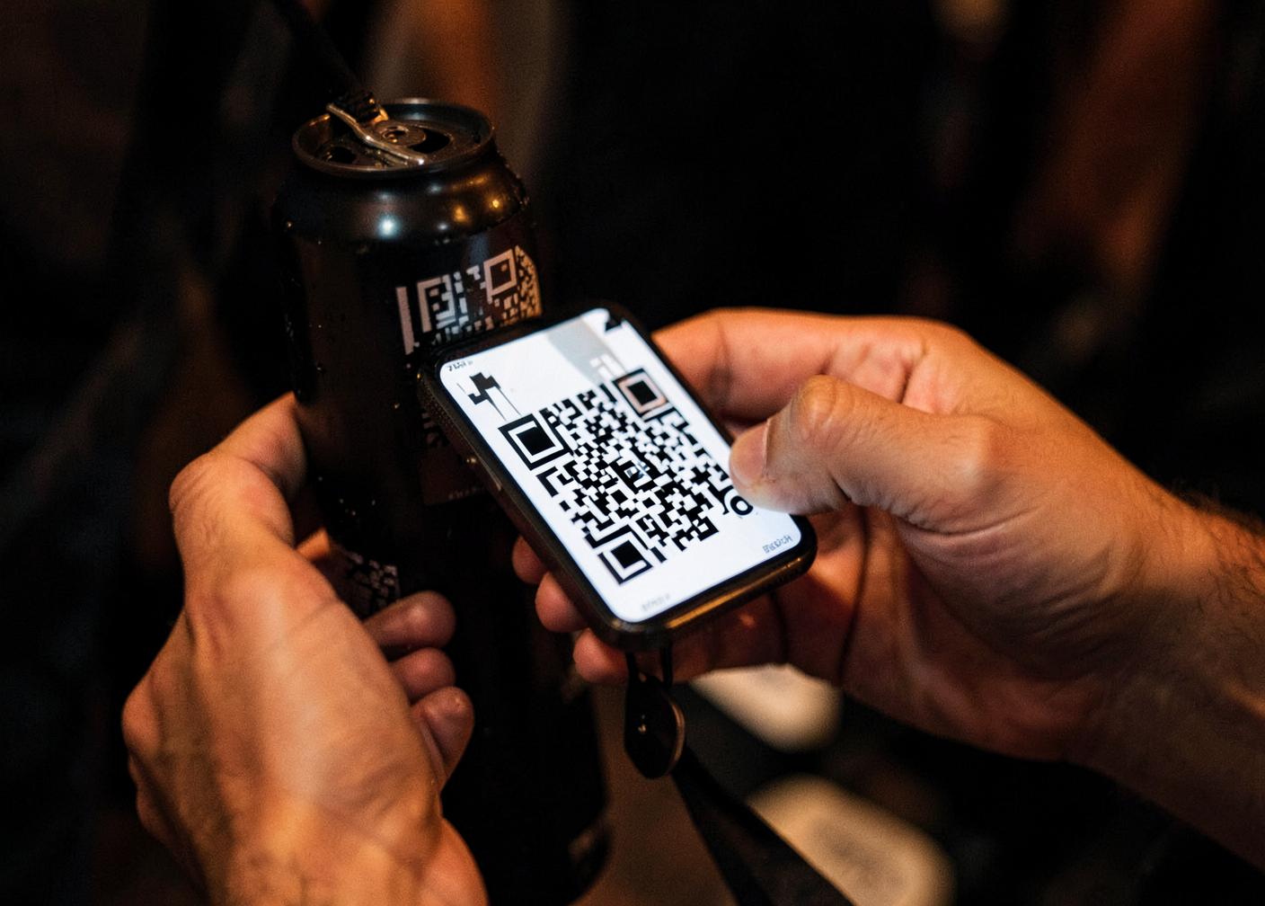 A delegate scanning a QR code on a can with their phone